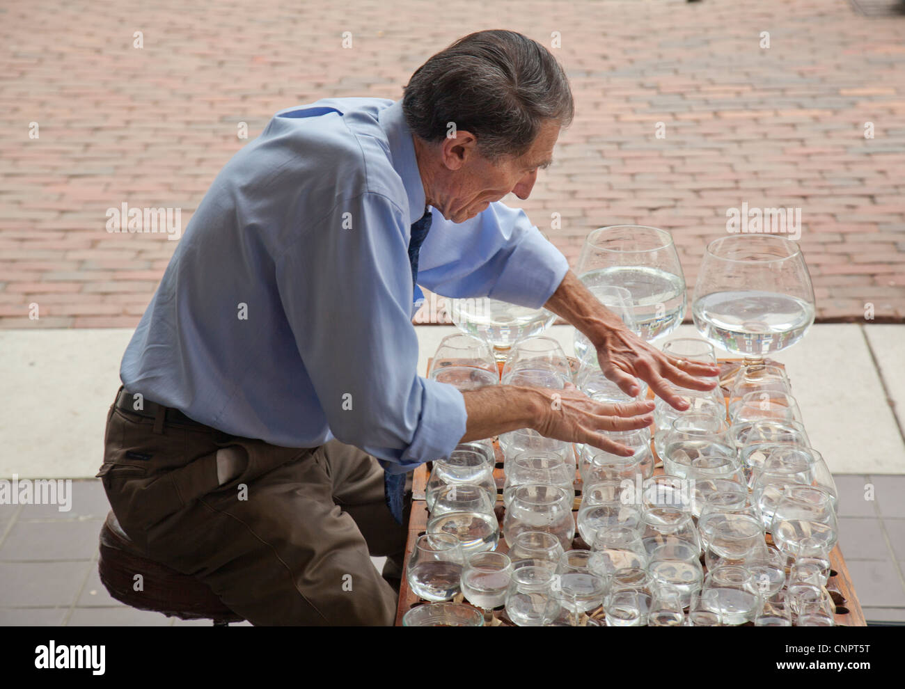 Uomo a fare musica con bicchieri di acqua Foto stock - Alamy