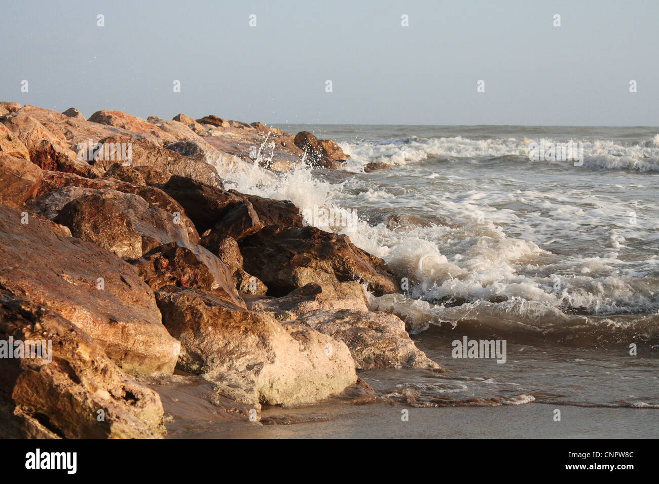 Una foto di una sequenza di un onda che si frantuma sulla barriera corallina (scogliera) nell'ora d'oro. Foto Stock