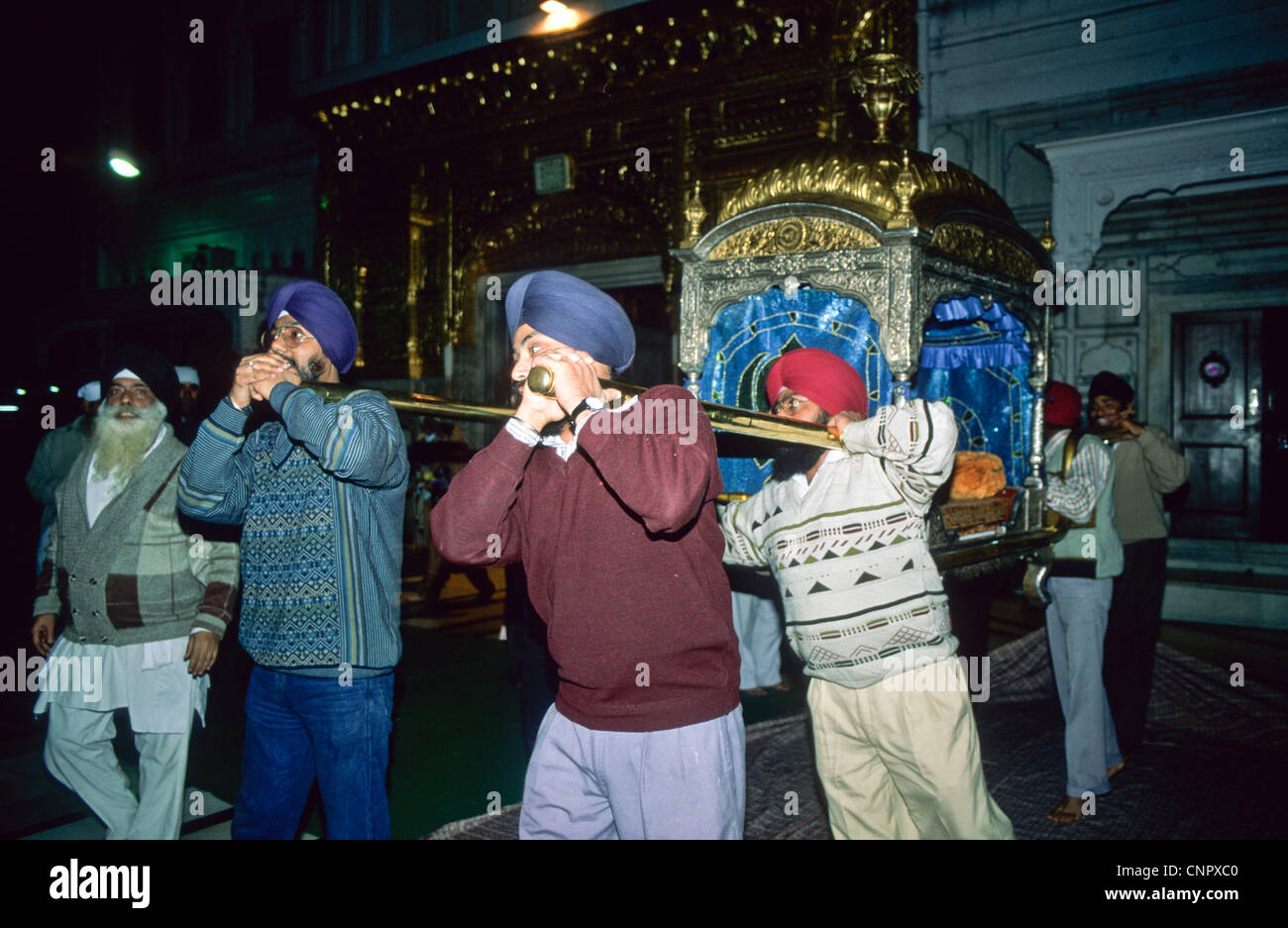 I sikh che trasportano il Guru Granth Sahib (sikh libro sacro) al Tempio d'oro di Amritsar, India. Foto Stock