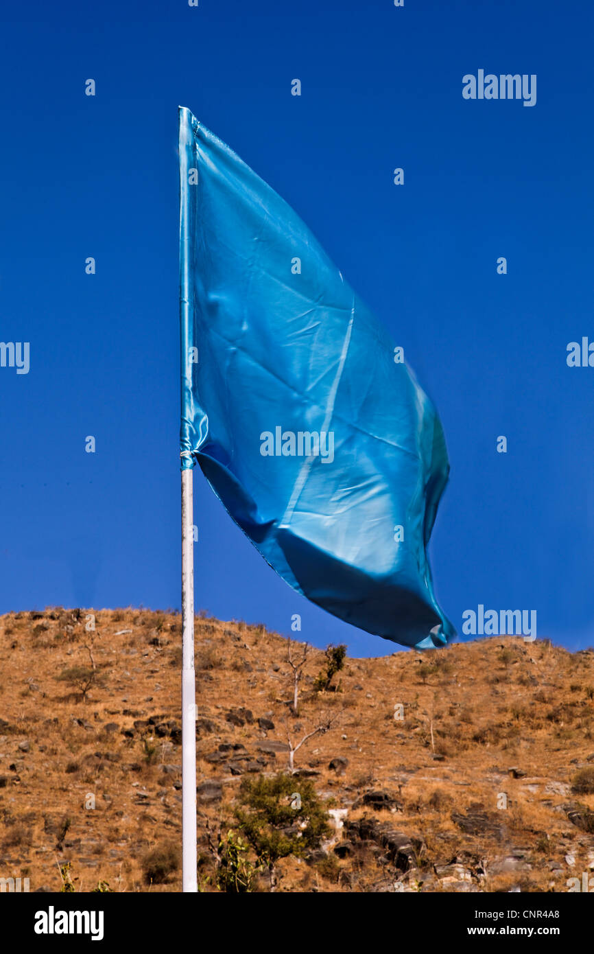 Ritratto di un pennone verticale con un setoso blu-turchese bandiera sventolare nel vento Foto Stock
