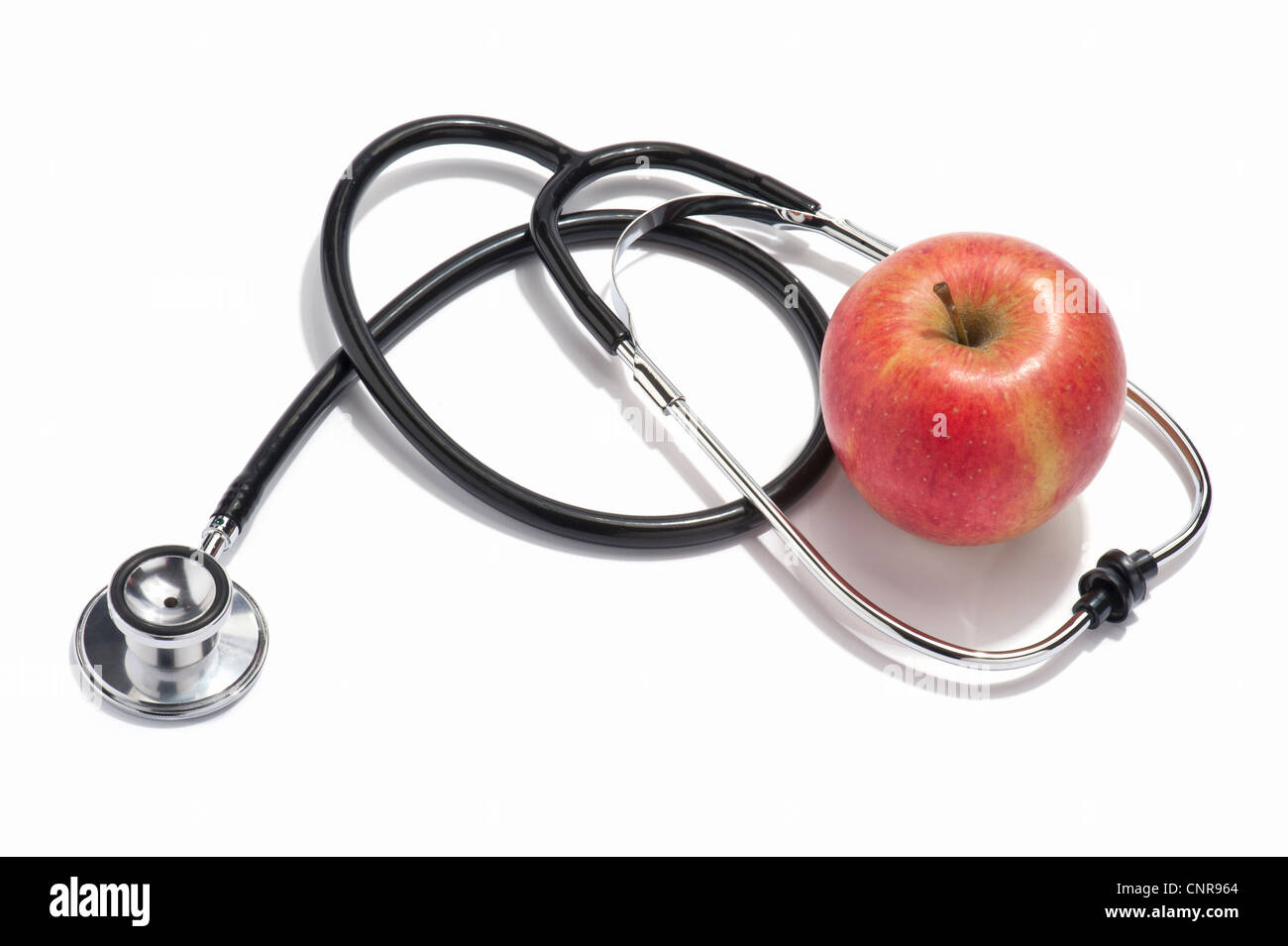 Un medici lo stetoscopio e una mela rossa Foto Stock