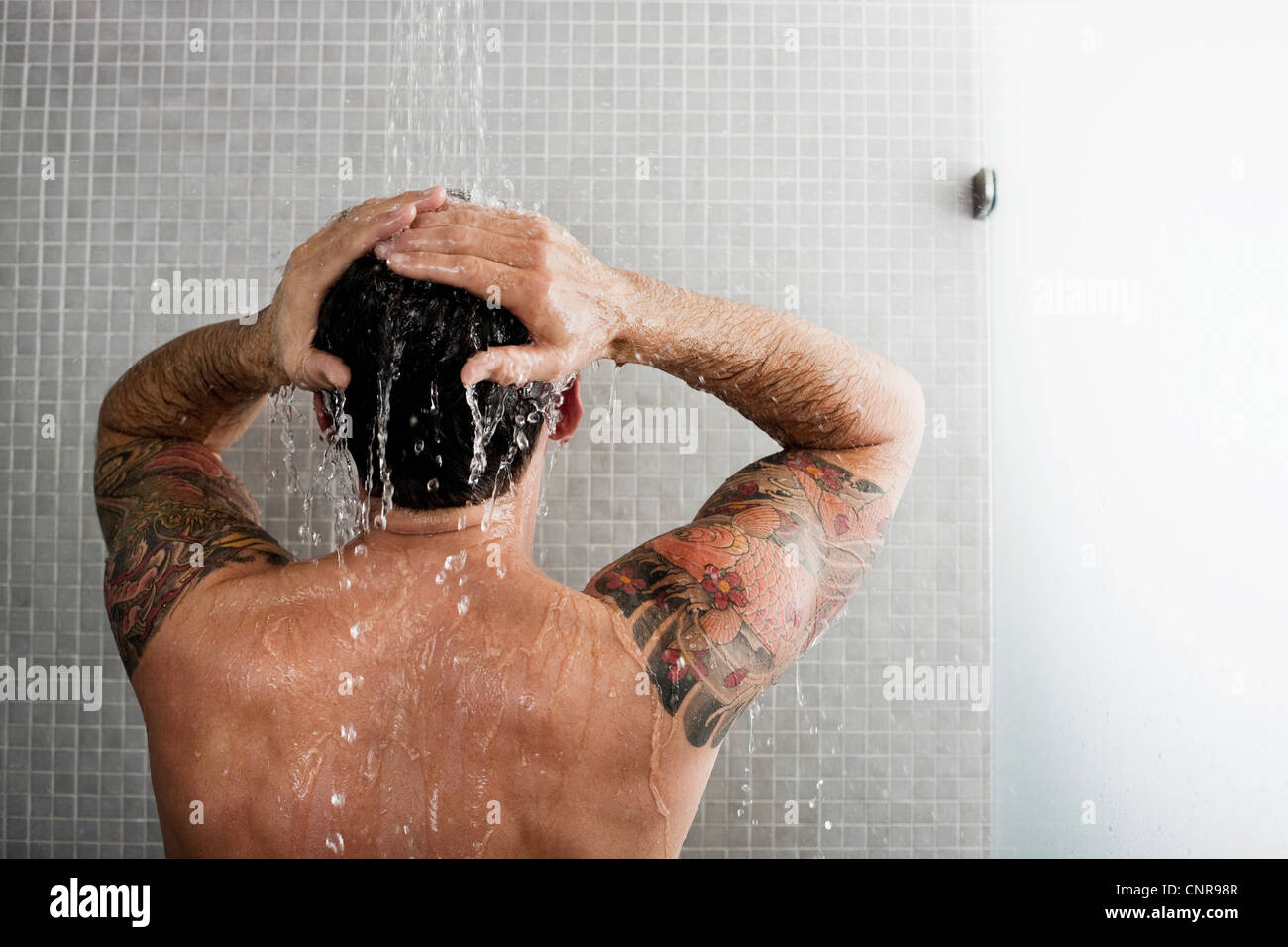 Lavaggio uomo i suoi capelli nella doccia Foto stock - Alamy