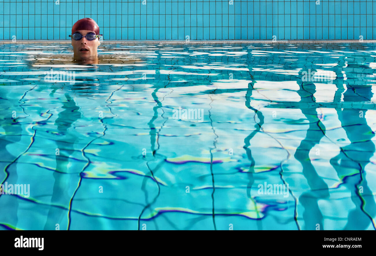 Uomo di nuoto in piscina interna Foto Stock