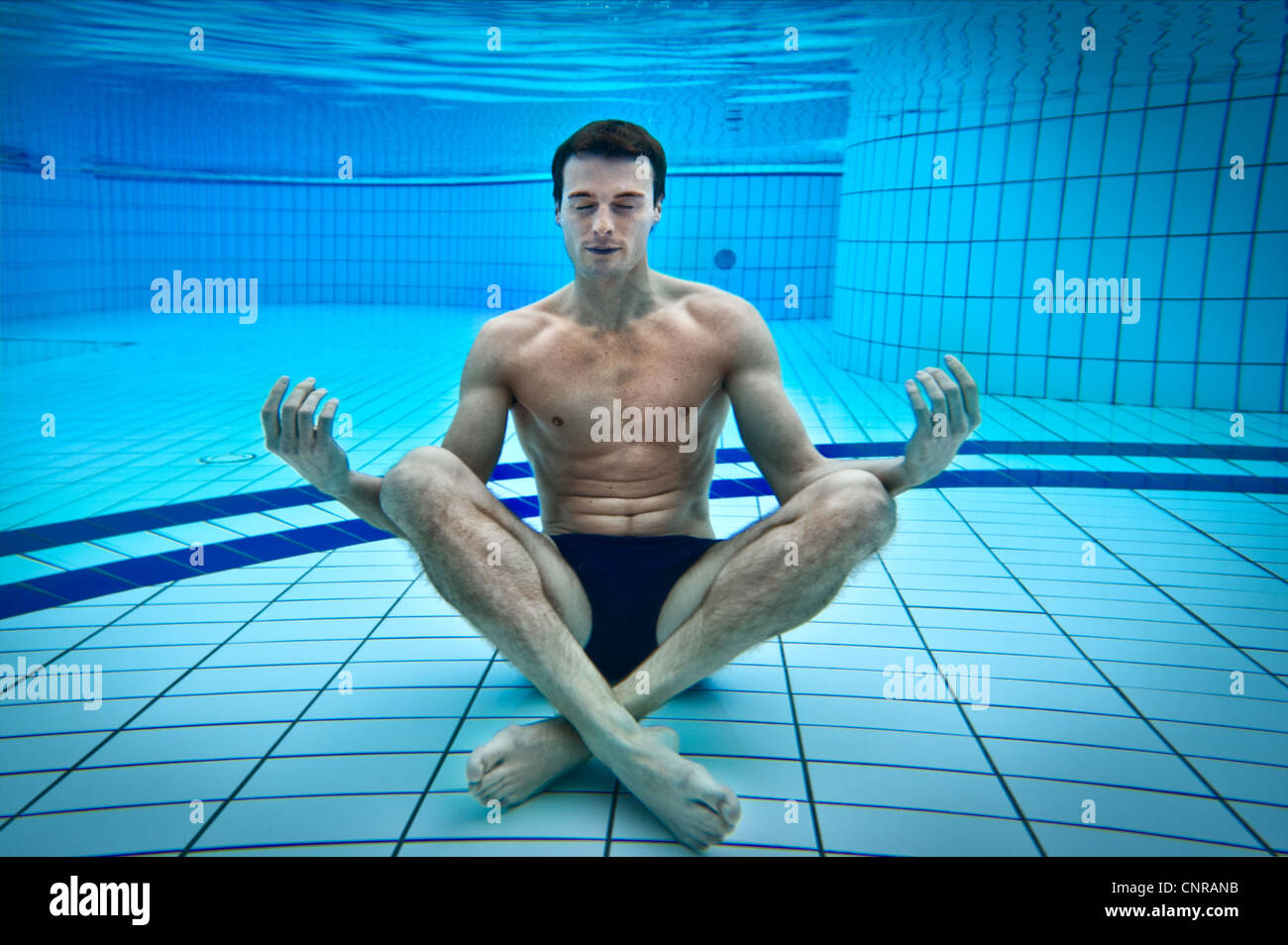 L'uomo meditando in piscina Foto Stock