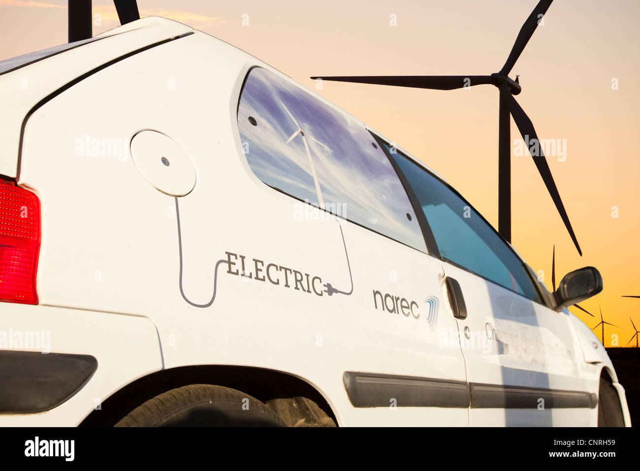 Un auto elettrica all'alba su Whitlee wind farm su Eaglesham Moor appena a sud di Glasgow in Scozia, Regno Unito, Foto Stock