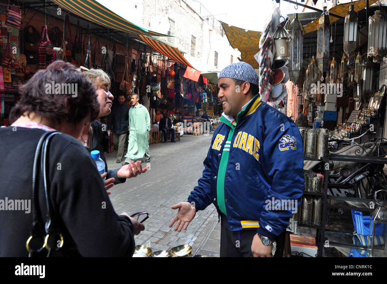 Una strada venditore cerca di vendere ai turisti nella Medina di Marrakech Foto Stock