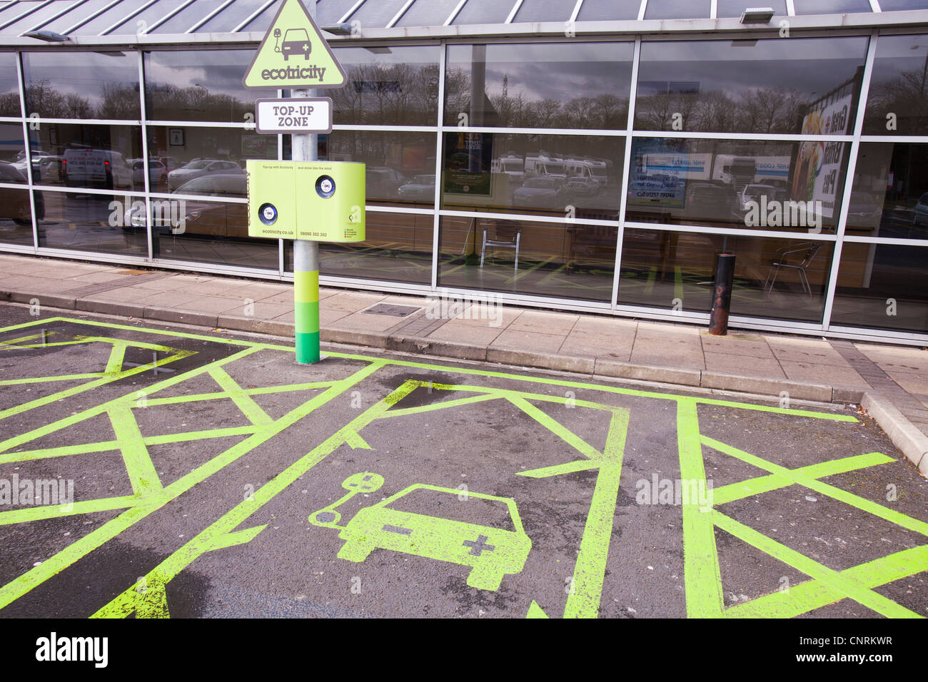 Un auto elettrica con stazione di ricarica al Charnock Richard M6 stazione di servizio autostradale, Lancashire, Regno Unito. Foto Stock