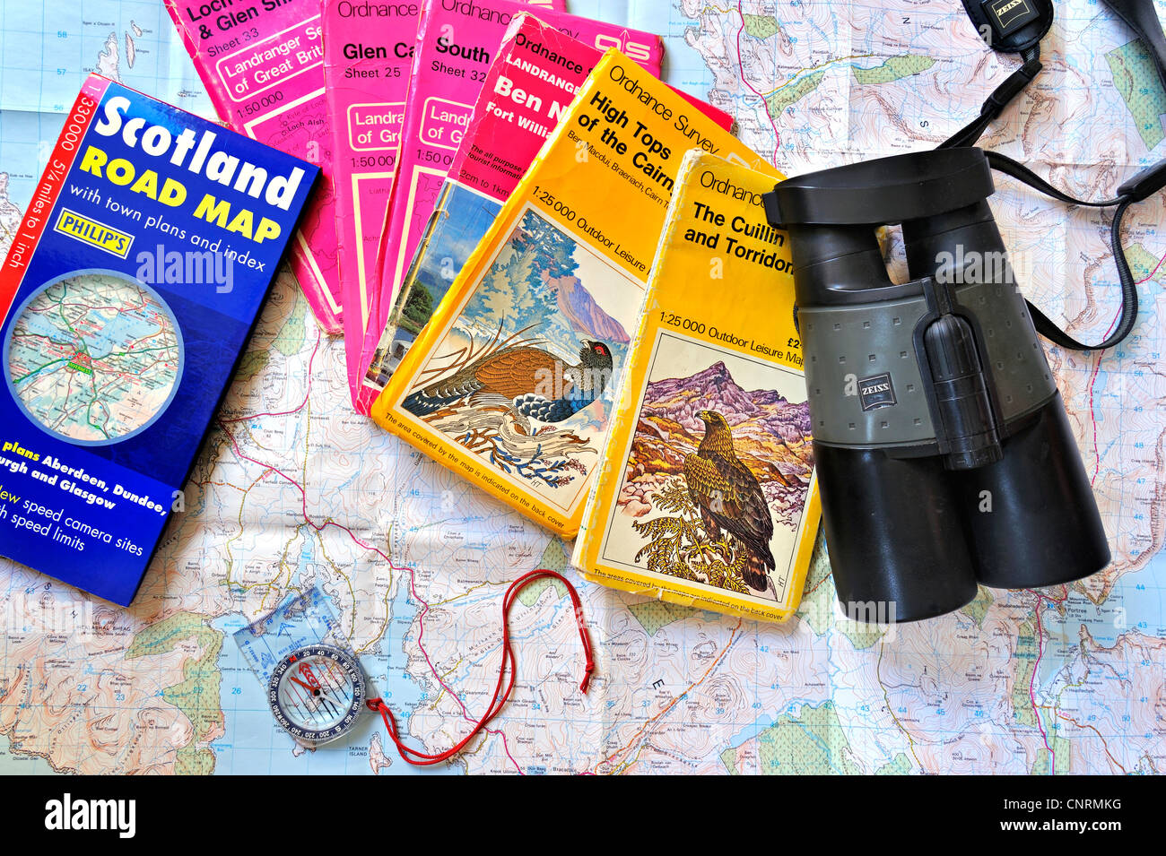 Bussola Binocolo e assortimento di Scottish Ordnance Survey mappe topografiche sulla Scozia, Regno Unito al piano di viaggio della fauna selvatica Foto Stock