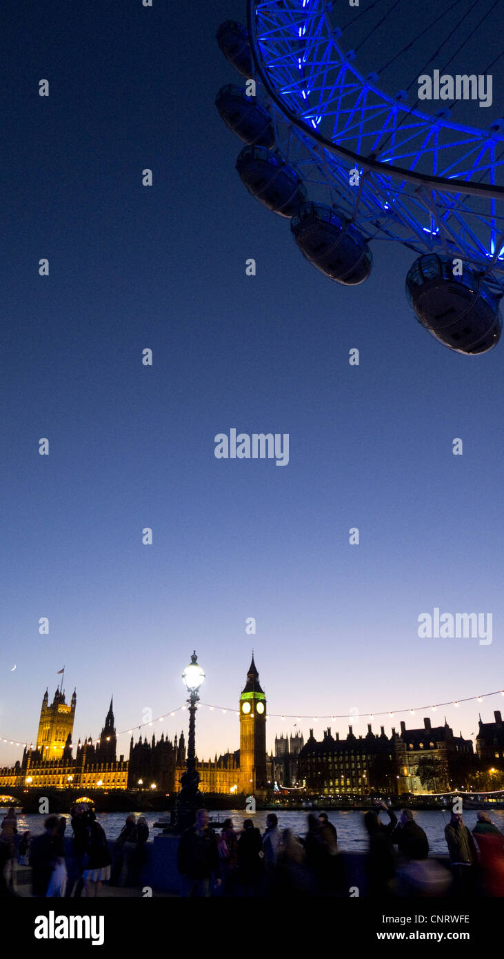 Il London Eye al crepuscolo, guardando attraverso il fiume Tamigi per il Big Ben e il Parlamento Foto Stock