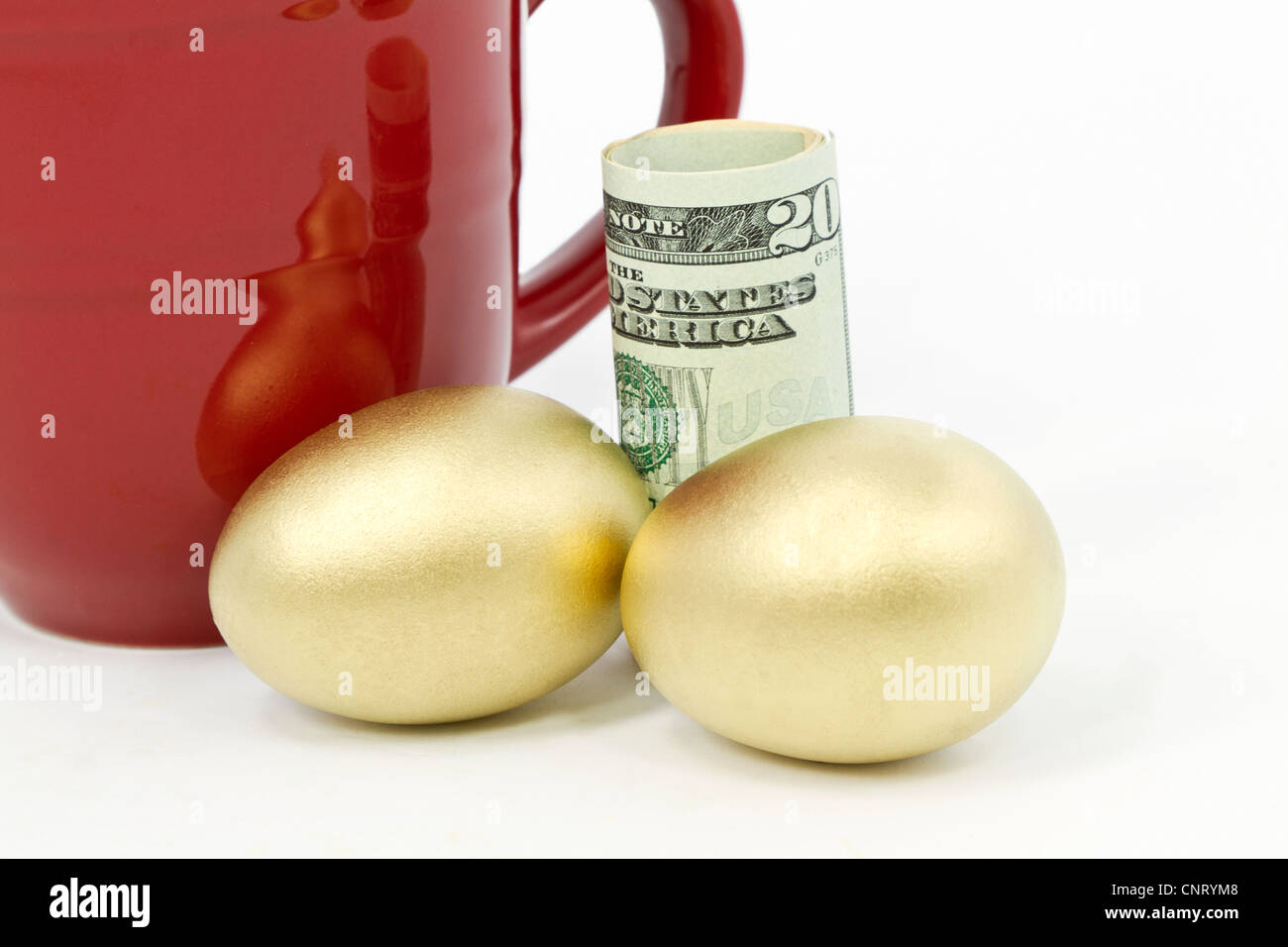 Due, oro nest uova deposte nella parte anteriore del dollaro valuta e rosso, tazza da caffè Foto Stock