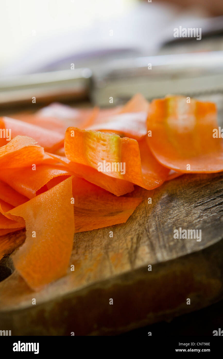 Sottili fette di carota sul bordo di taglio Foto Stock