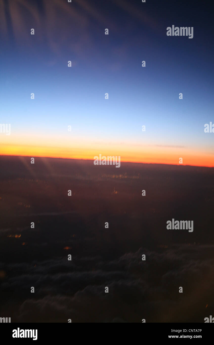 Sfocata vista tramonto al di fuori della finestra di aeroplano Foto Stock
