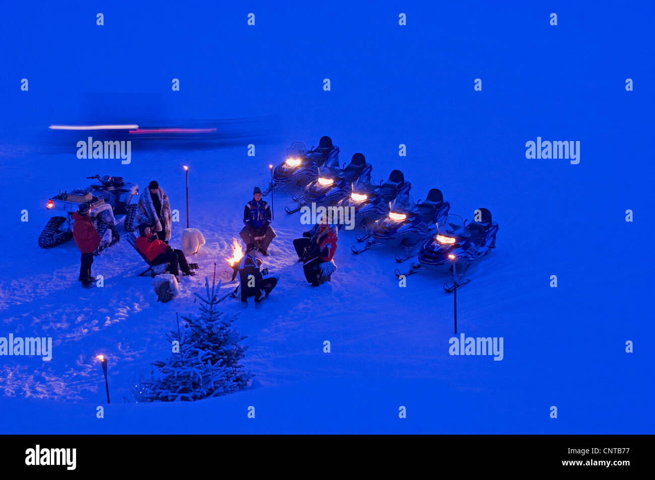 Riunione serale attorno a un fuoco nella neve in una stazione sciistica, Francia, Savoie, Val-d'Isre Foto Stock