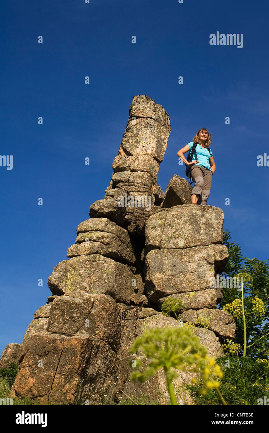 Donna in piedi su una cosa bizzarra roccia a forma di ago godendo la vista, Francia, il Parco nazionale di Cevennes Foto Stock