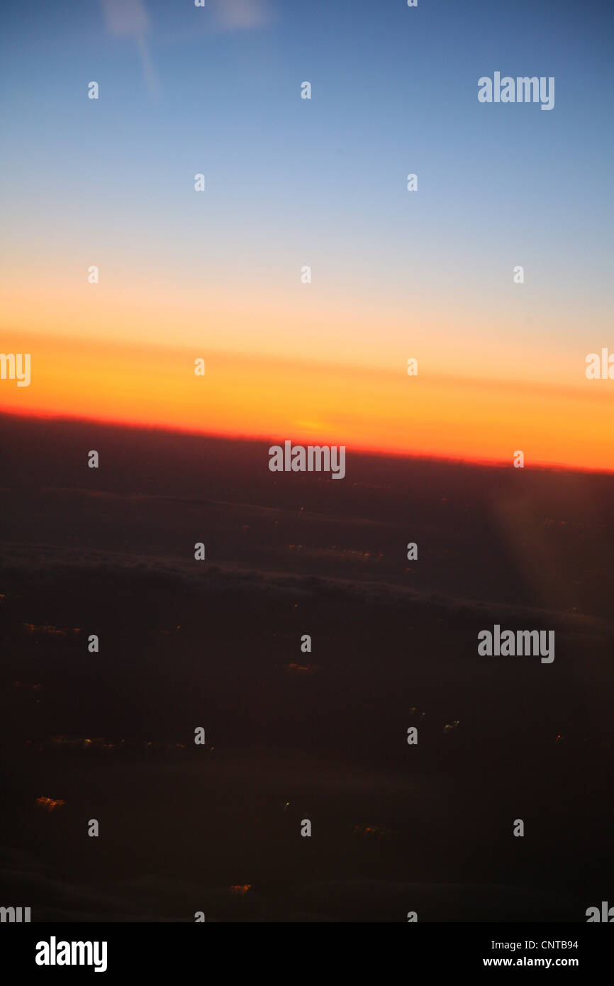 Sfocata vista tramonto al di fuori della finestra di aeroplano Foto Stock