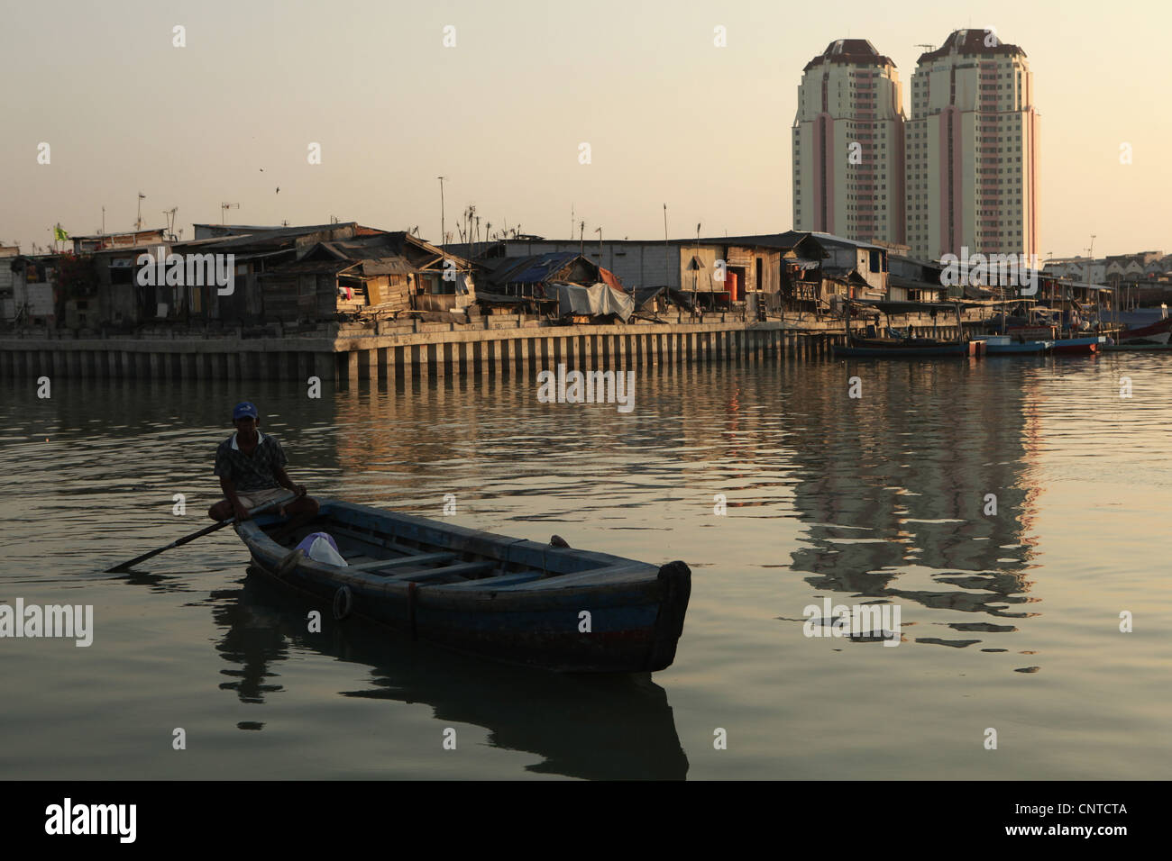 Baraccopoli zona con nuovi edifici dietro nello storico Porto di Sunda Kelapa a Jakarta, Indonesia. Foto Stock