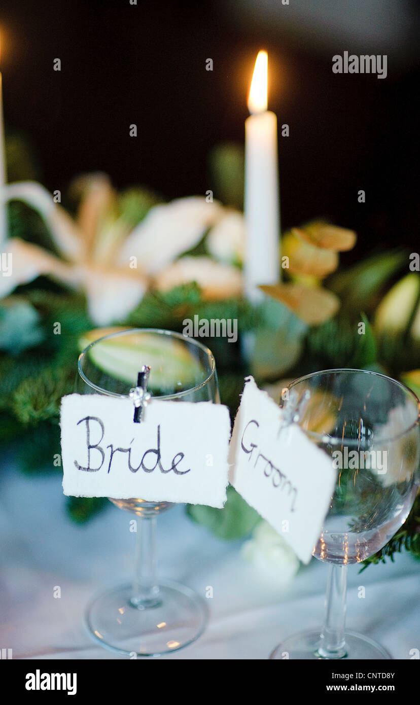 La prima colazione di nozze tavoli reception con candele, doni, la sposa e lo sposo nome luoghi ritagliato per bicchieri da vino Foto Stock