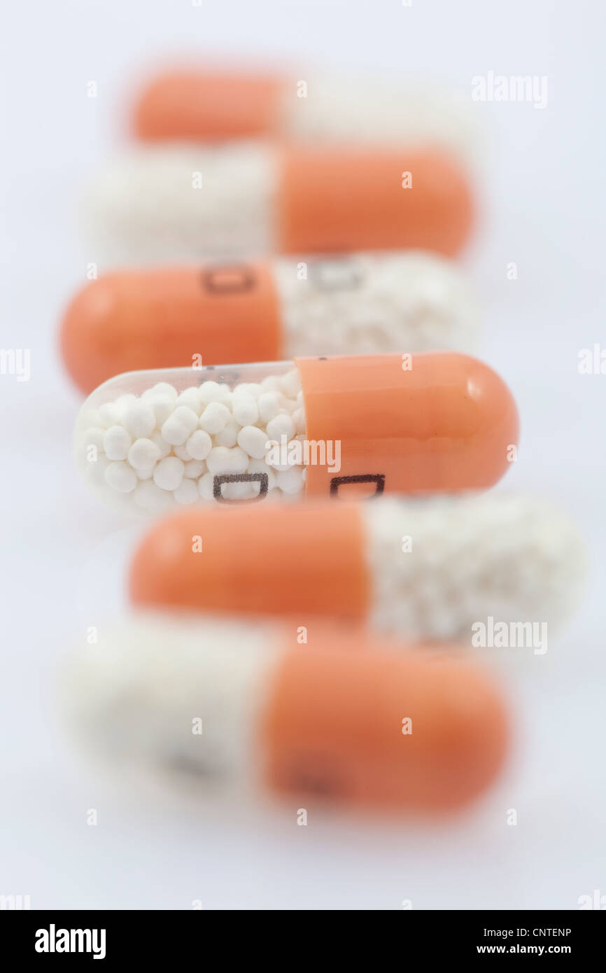 Scatter antibiotico in capsule su sfondo bianco Foto Stock