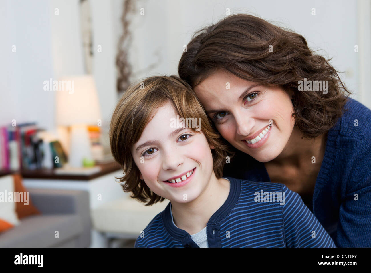 Madre e figlio abbracciando in salotto Foto Stock