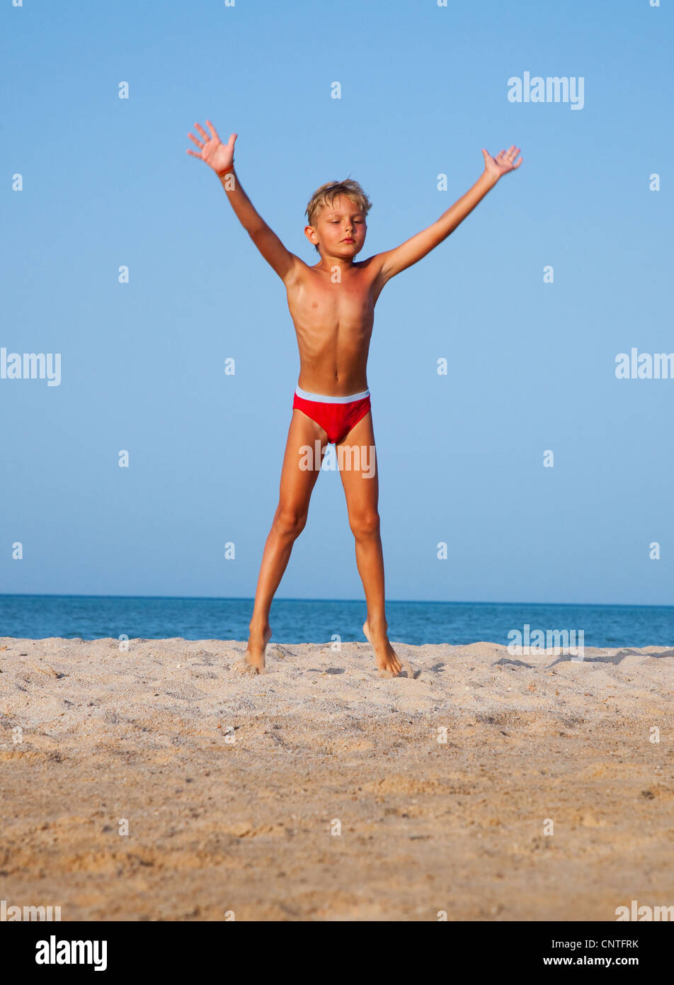 Il Ragazzo Salta In Alto Sulla Spiaggia Di Sabbia Vicino Al Mare Foto Stock Alamy