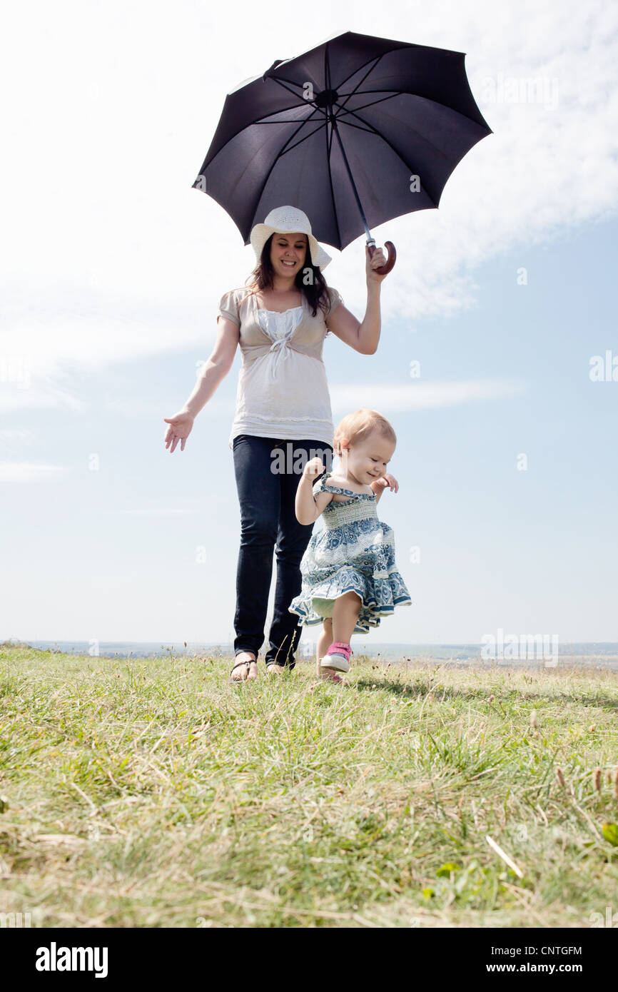 Donna con la figlia e ombrellone Foto Stock