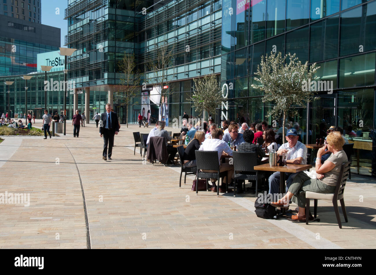 I lavoratori e i turisti unseasonably godono di un clima caldo nel marzo 2012 a MediaCityUK, Salford Quays, Manchester, Inghilterra, Regno Unito Foto Stock