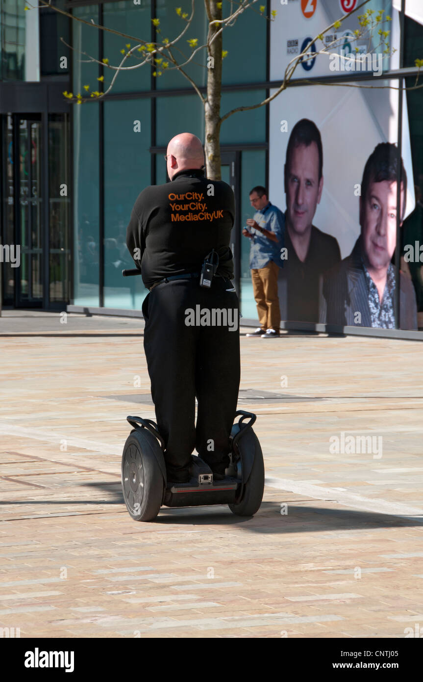 La guardia di sicurezza su un Segway personal transporter a MediaCityUK, Salford Quays, Manchester, Inghilterra, Regno Unito Foto Stock