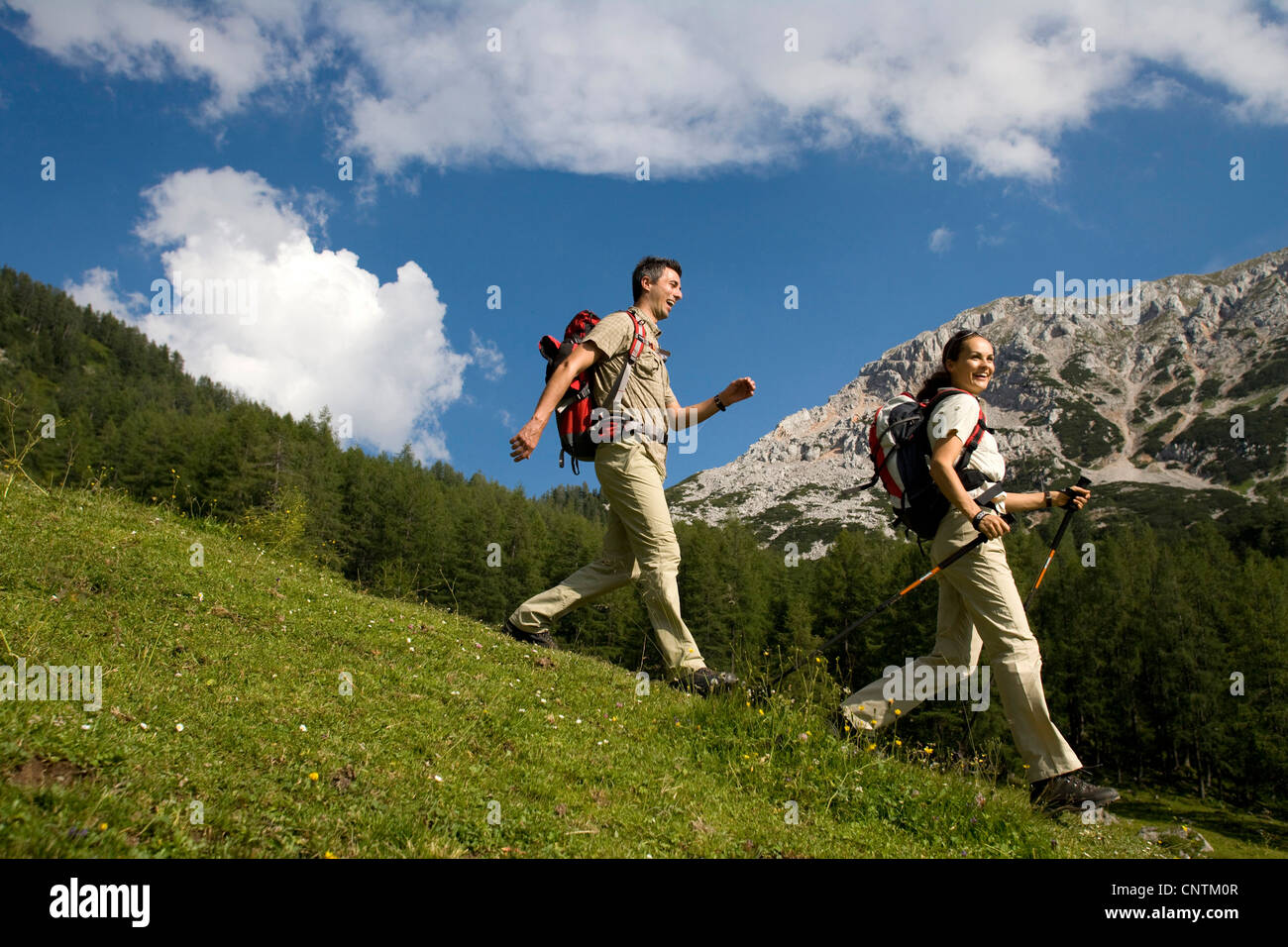 Giovane vagare in un paesaggio di montagna. L uomo e la donna a piedi attraverso un prato, Austria, Austria superiore, Gmunden Foto Stock