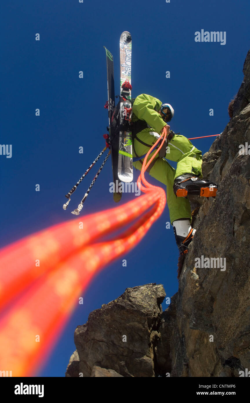 Alpinista di sci rapeling in corrispondenza di una parete di roccia, Francia, Alpi Foto Stock