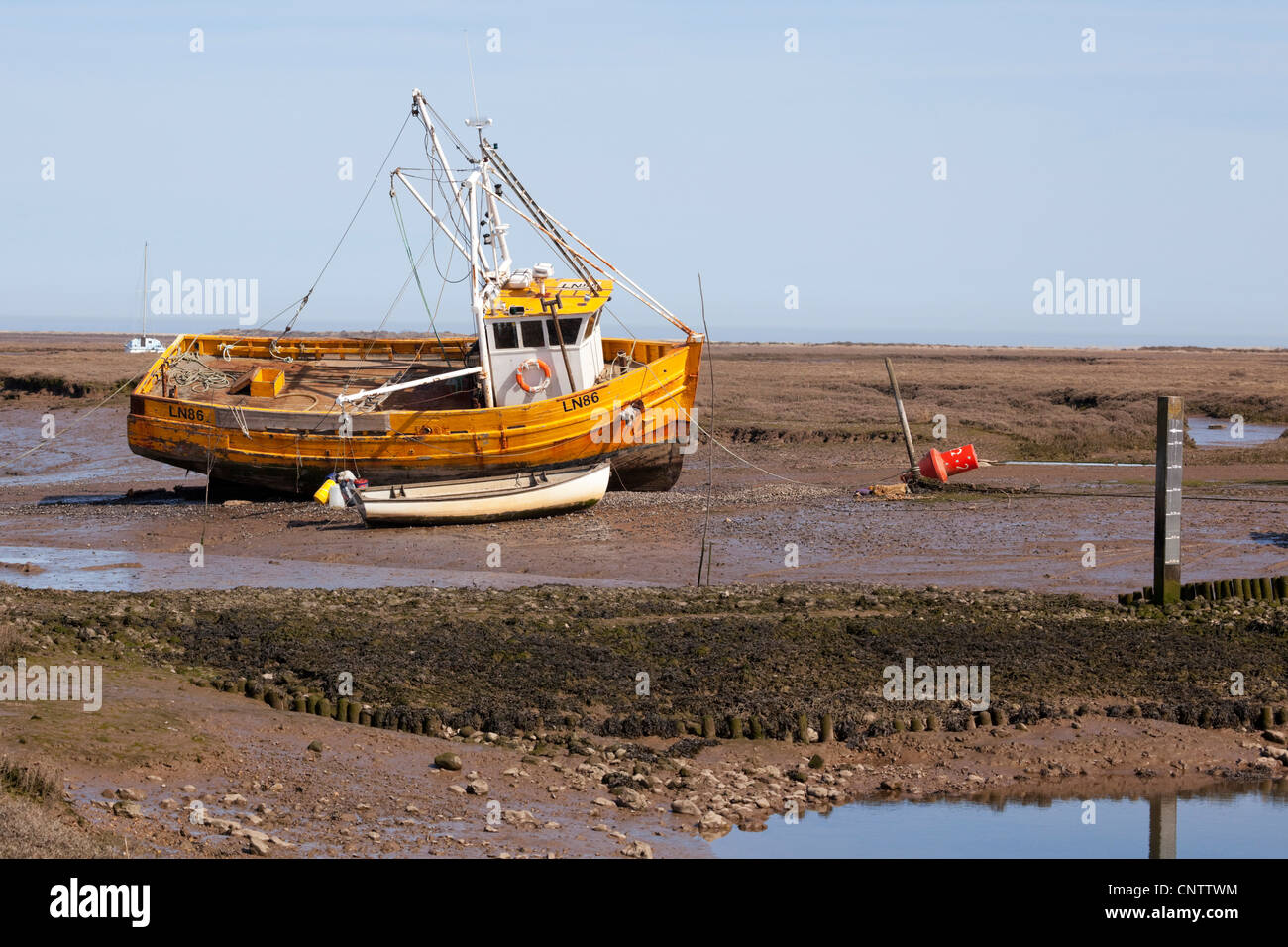 Di colore giallo brillante aragosta barca da pesca, Brancaster North Norfolk. Foto Stock