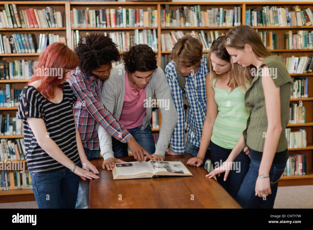Gli studenti la lettura di libro in biblioteca Foto Stock