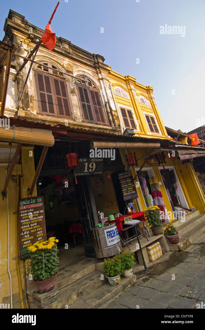 Paesaggio urbano verticale vista ramshackled vecchie case di Hoi An Old Town, Vietnam su una soleggiata sera. Foto Stock