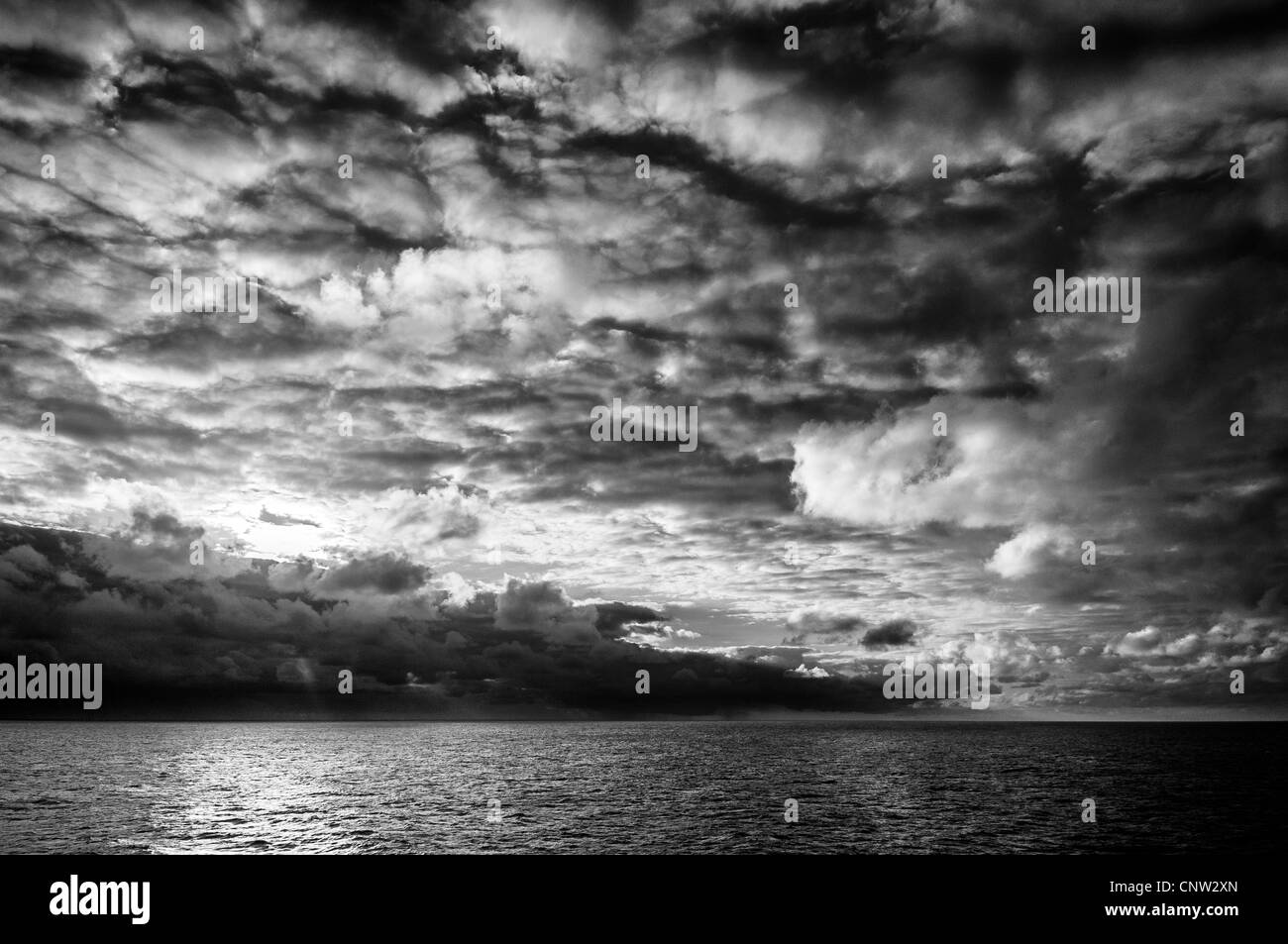 Drammatica immagine in bianco e nero di un cielo tempestoso sull'oceano Foto Stock