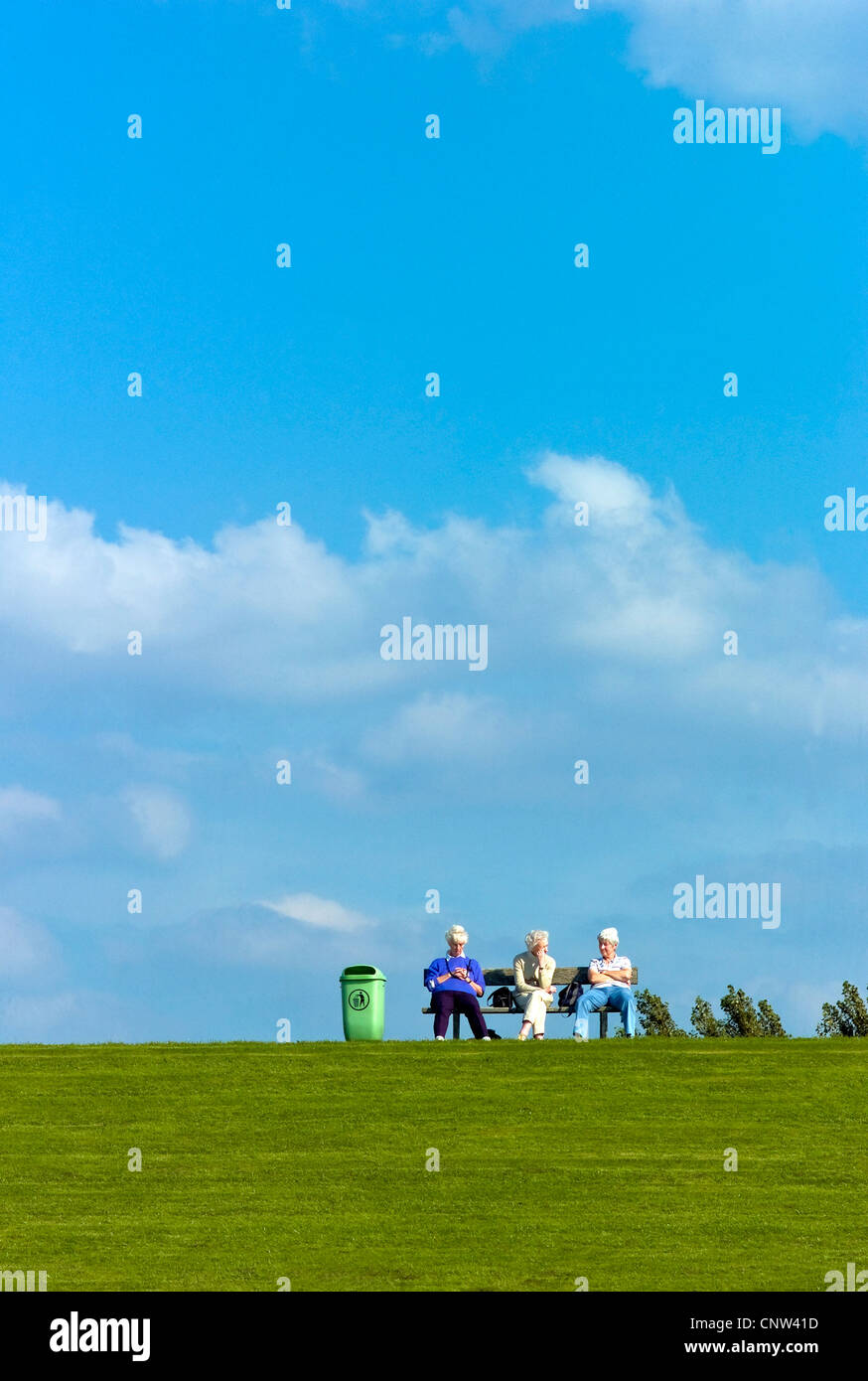 Tre bianchi dai capelli donna seduta su una panchina su una diga del Mare del Nord in Dorum-Neufeld, Germania, Bassa Sassonia Foto Stock