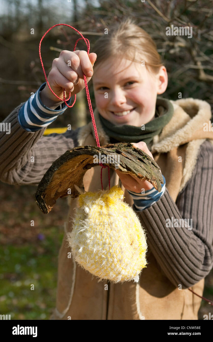 Ragazza presentando un self-made dispenser per materiale di nesting Foto Stock