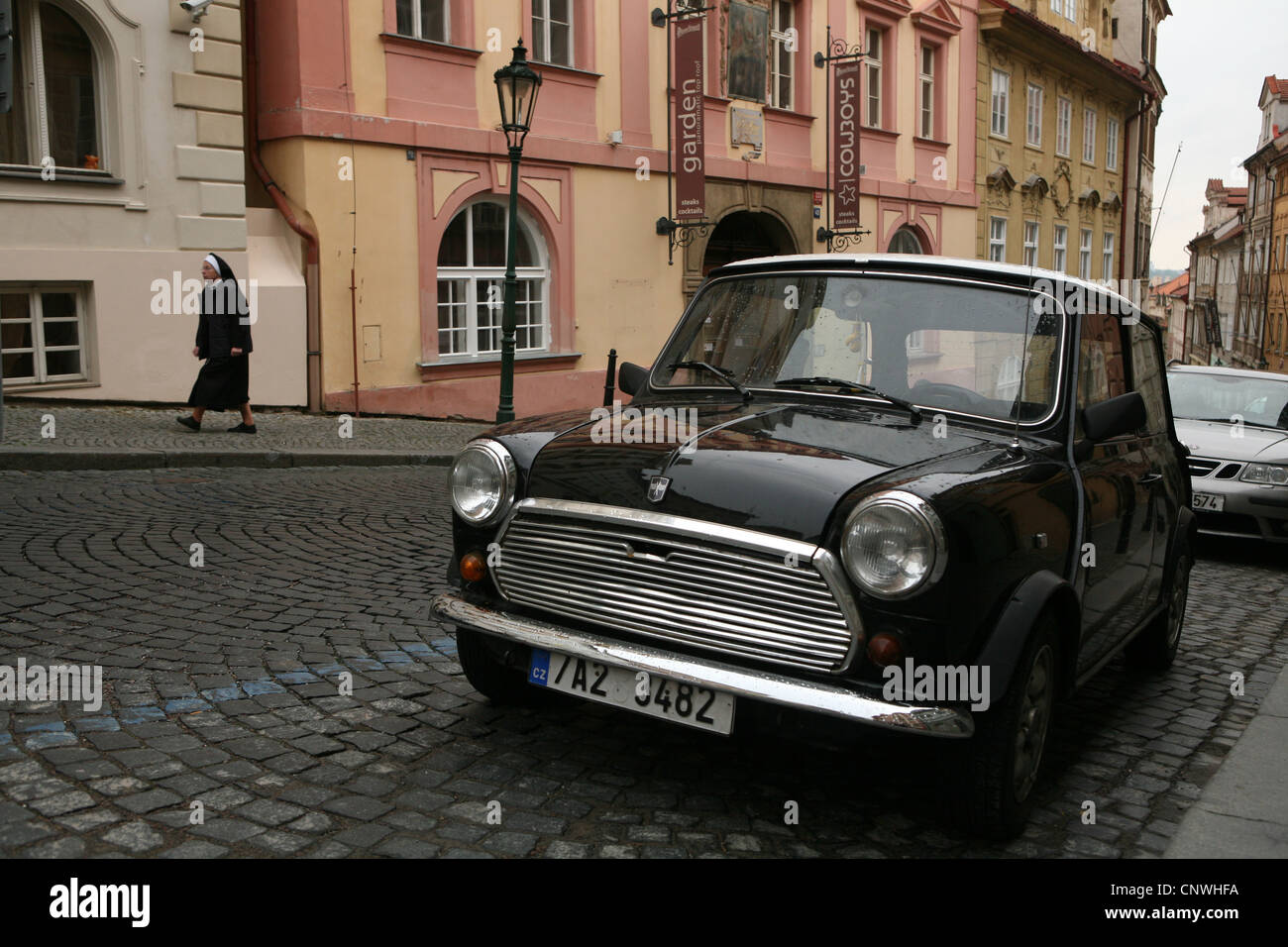 Suora cattolica e Mini Cooper auto in Via Nerudova a Praga, Repubblica Ceca. Foto Stock