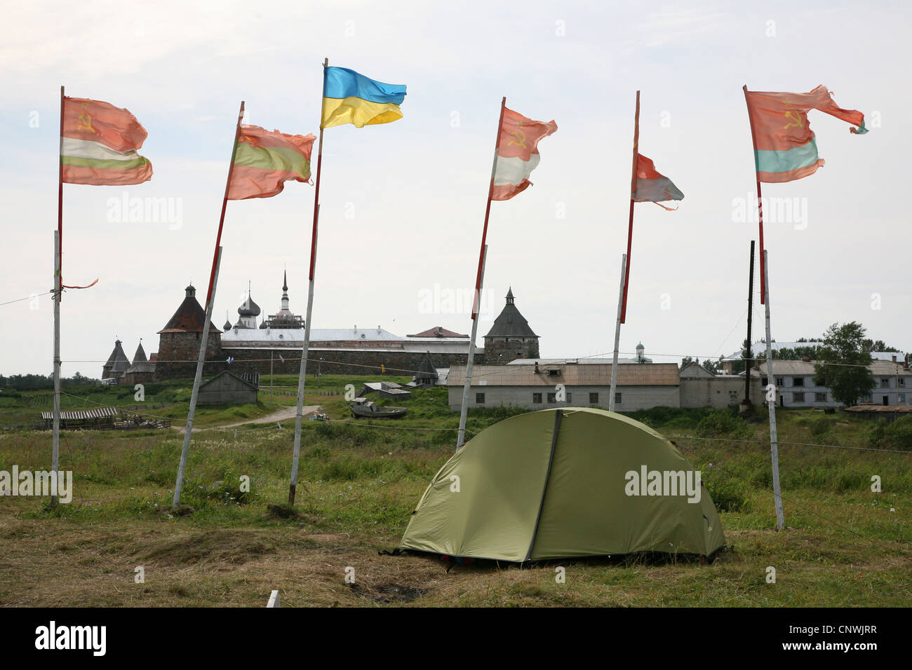 Antiche Repubbliche sovietiche bandiere accanto alla bandiera ucraino sventolare sopra il pellegrino camp su isole Solovetsky, Russia. Foto Stock