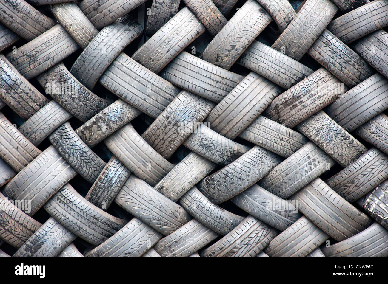 Uno sfondo immagine astratta di una parete realizzata interamente di pneumatici in gomma. Foto Stock