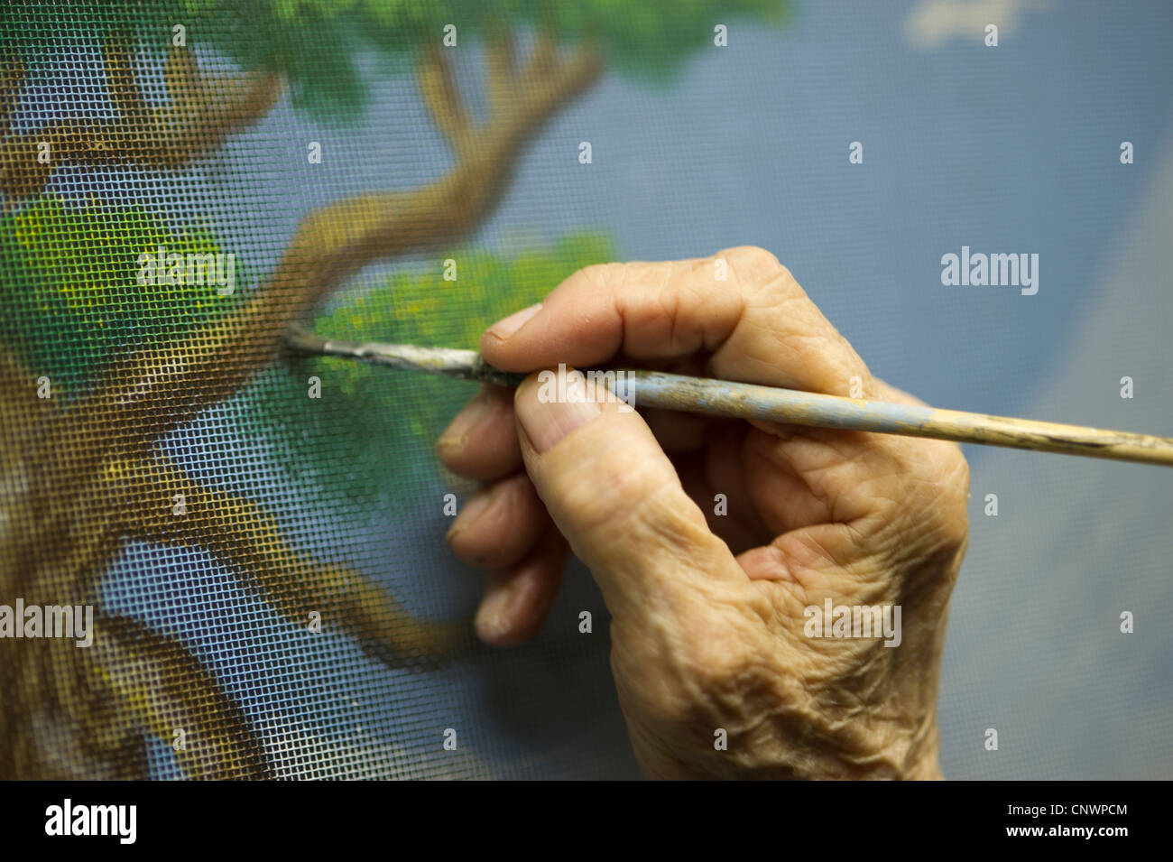 Artista tiene il pennello pittura una schermata in stile tradizionale di arte popolare di Baltimore Foto Stock