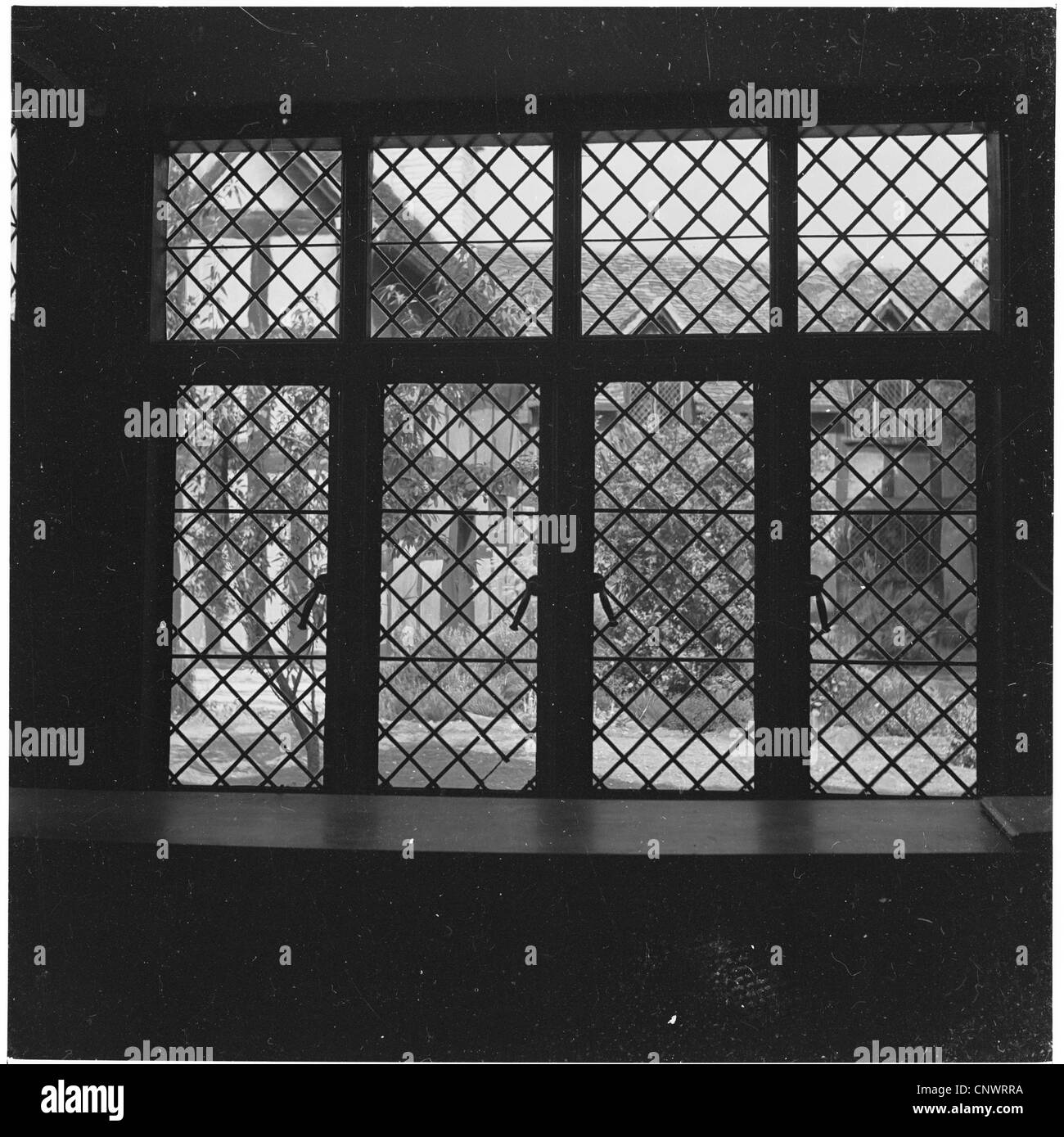 1960s. Una vista attraverso un Elizabethan finestra in vetro di Mary Arden's House, la madre di William Shakespeare. Foto Stock