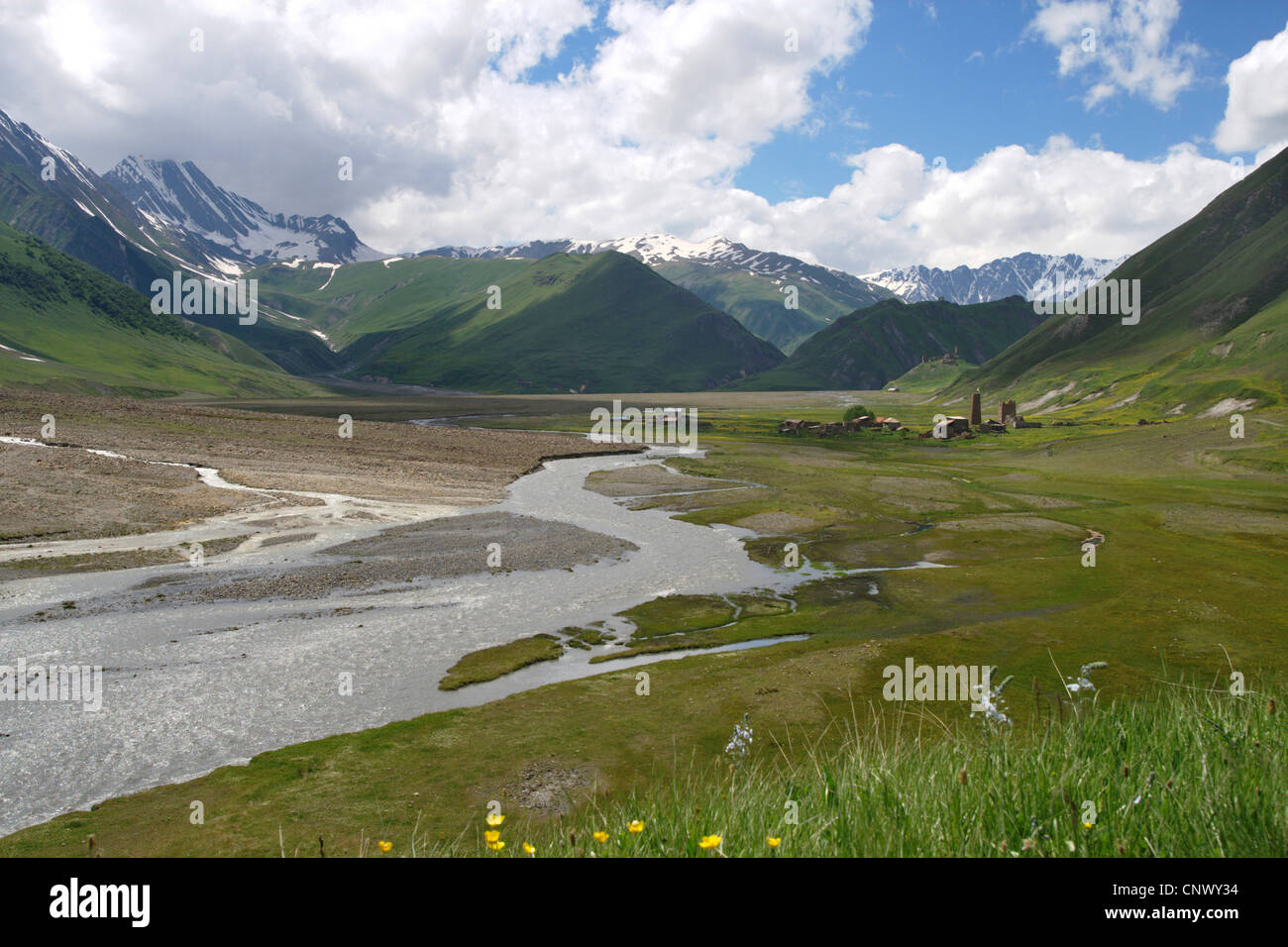 Ampia vallata con un fiume, un villaggio abandonned e una fortezza medievale nella parte anteriore del panorama di montagna, Georgia, Truso-Tal Foto Stock