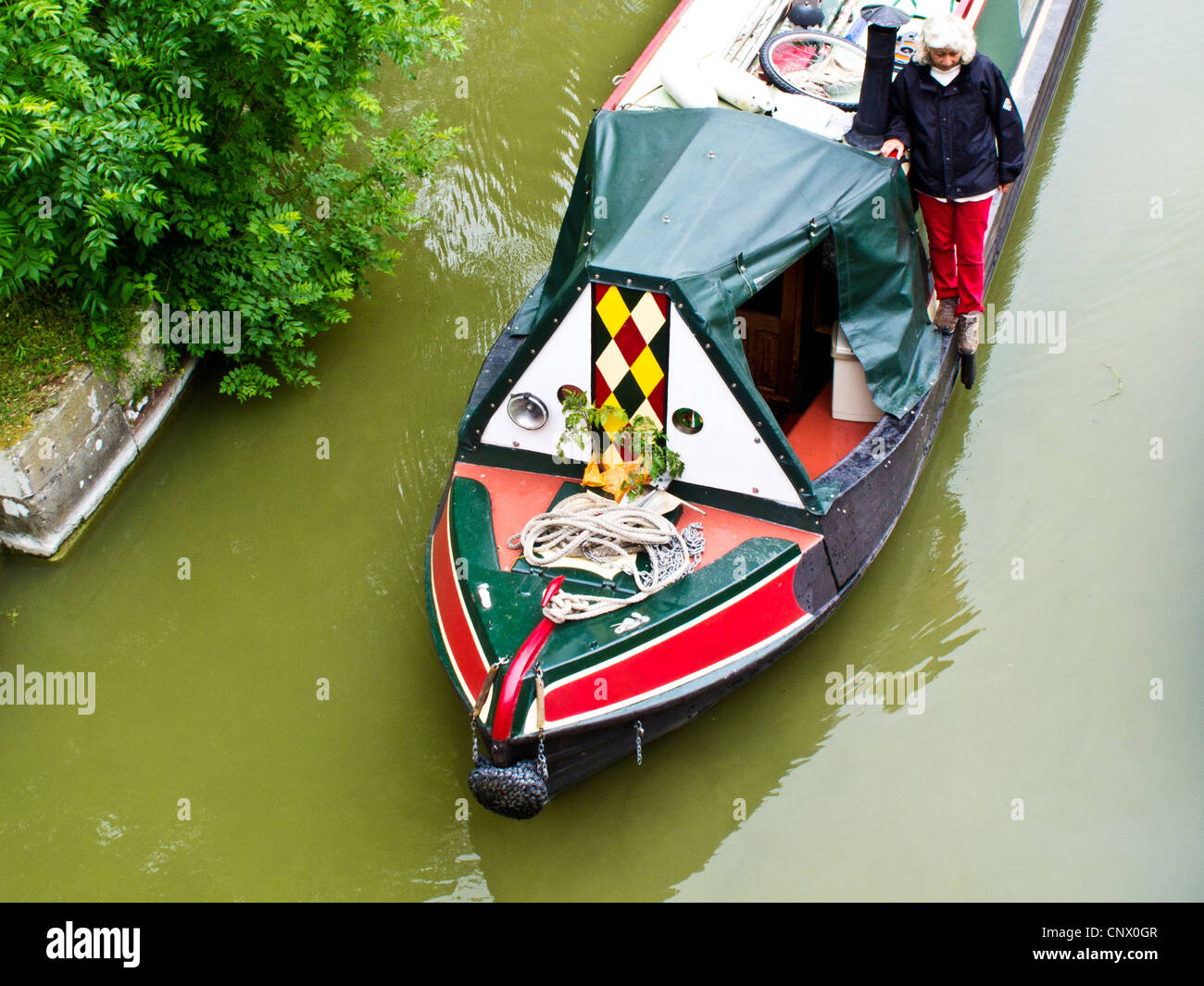 Narrowboat passando sotto un ponte in prossimità di Pewsey Wharf sul Kennet and Avon Canal nel Wiltshire, Inghilterra, Regno Unito Foto Stock