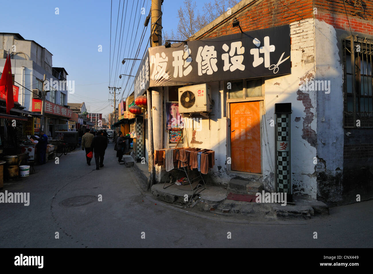 Negozi ed appartamenti in una parte della rete di vecchie strade ed edifici (hutong) ancora esistenti a Pechino in Cina. Foto Stock