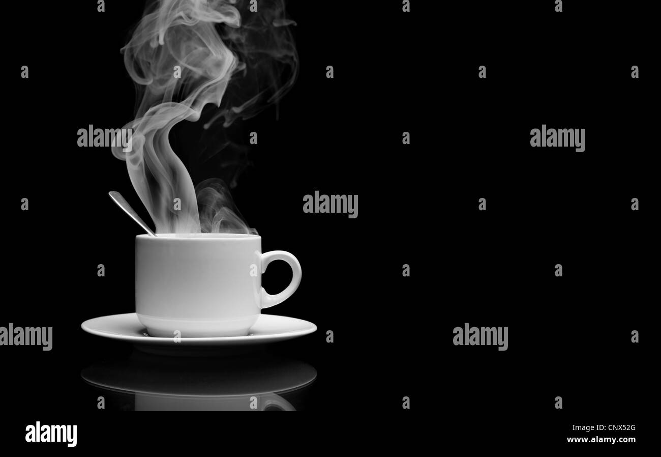 Tazza di una bevanda calda con vapore su sfondo nero Foto Stock