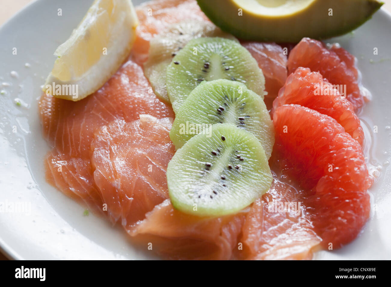 Un gustoso antipasto con salmone, avocado, kiwi e pompelmo rosa Foto stock  - Alamy