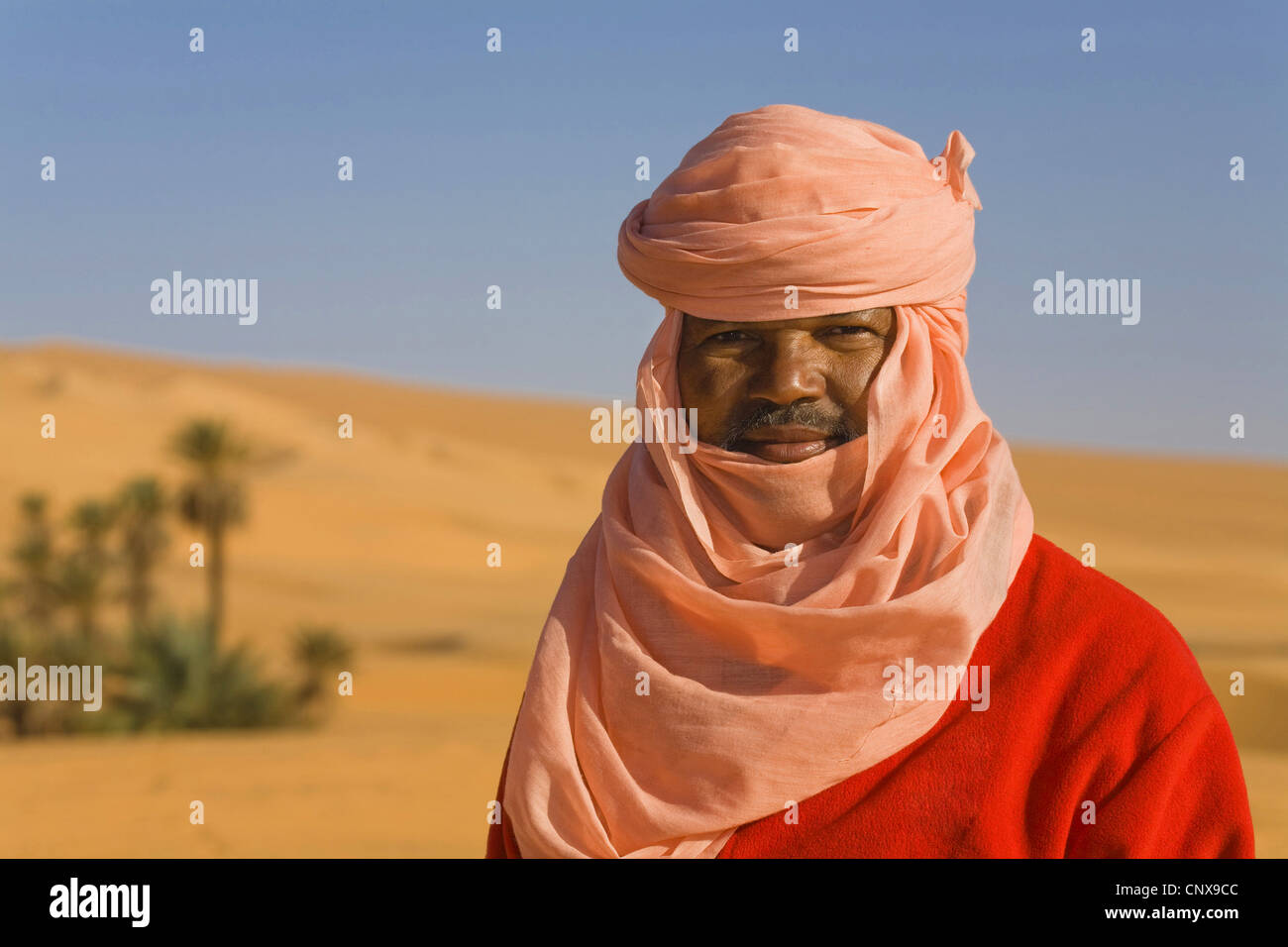 Ritratto di un Tuareg nel deserto nella parte anteriore del palm oasis, Libia, Sahara, Um el Ma Foto Stock
