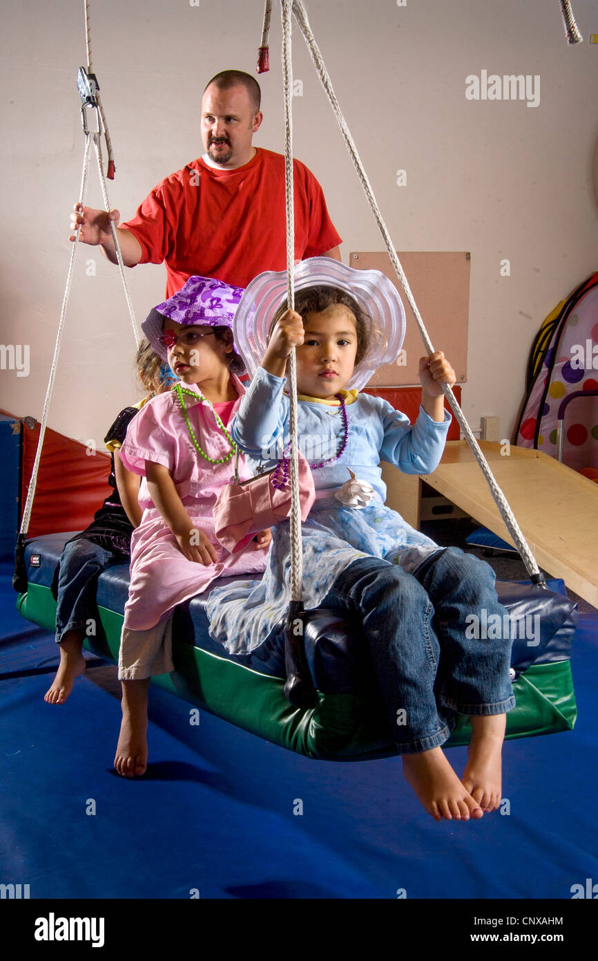 Come un insegnante di orologi, parzialmente vedenti ragazze indossare costumi per Dress-up come guidare una oscillazione durante una qualificazione professionale di classe. Foto Stock