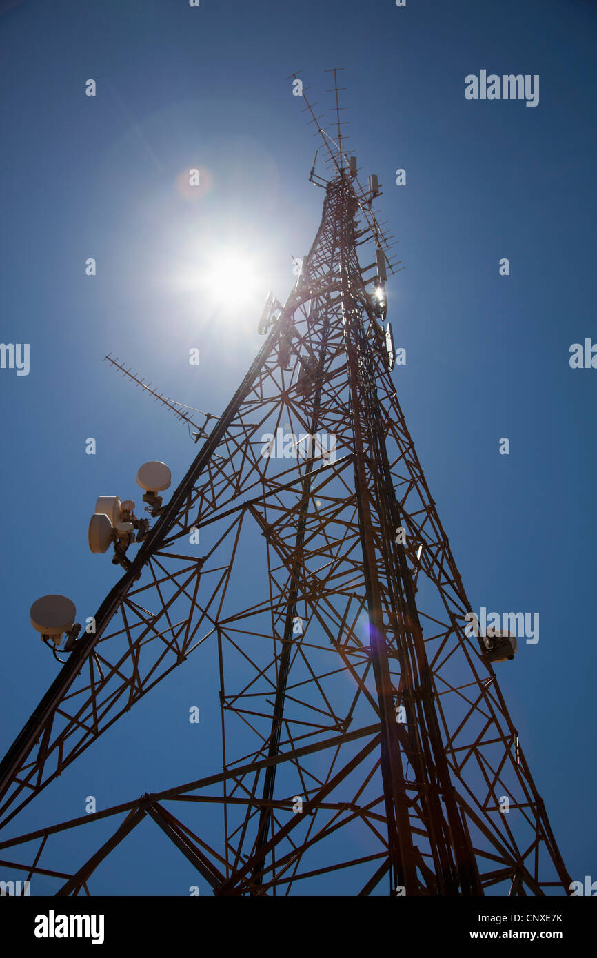 Sole che splende in giù su di una torre di comunicazione Foto Stock