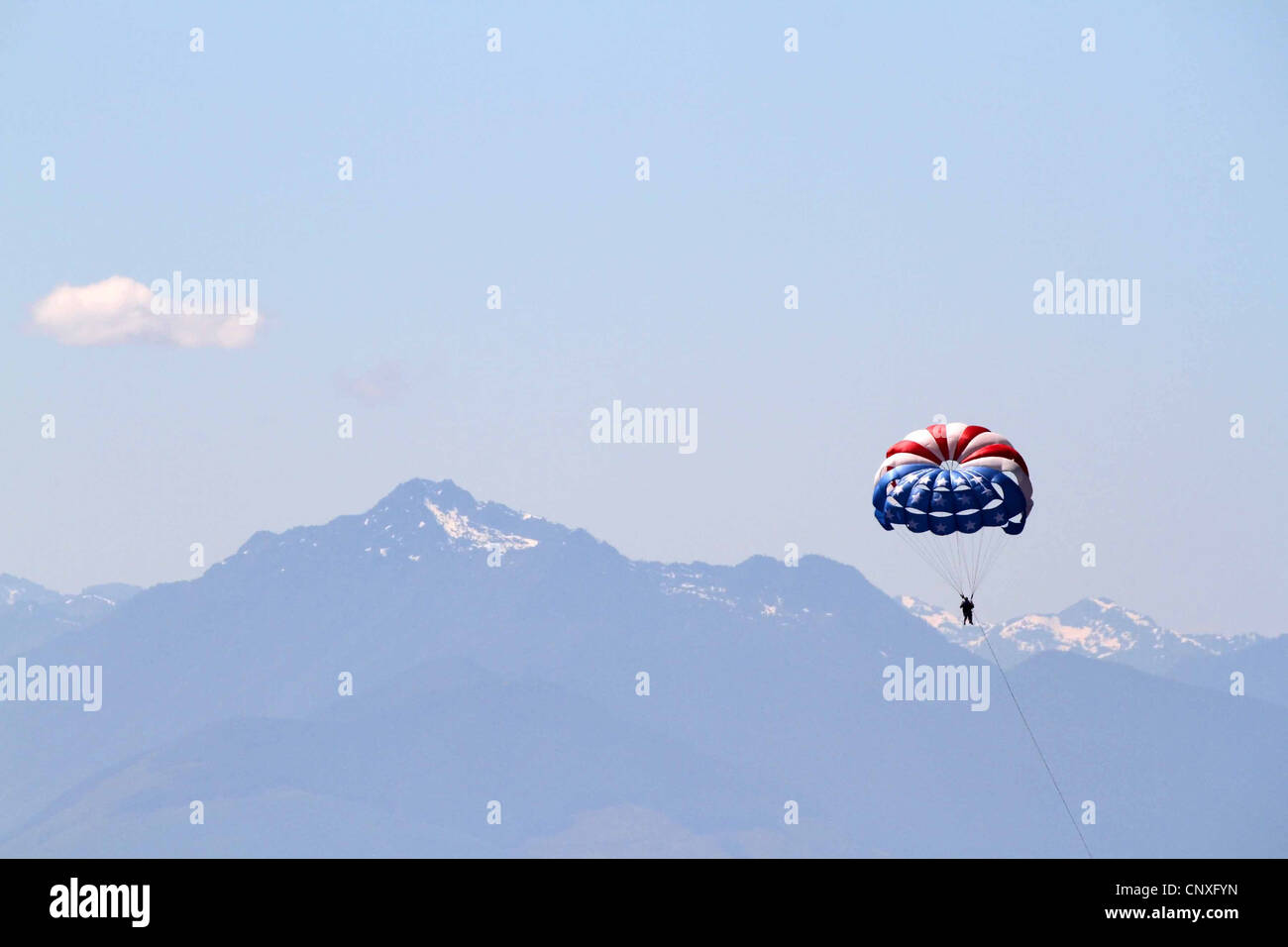 Il parasailing a Seattle, USA, con una vista delle montagne rocciose della distanza Foto Stock