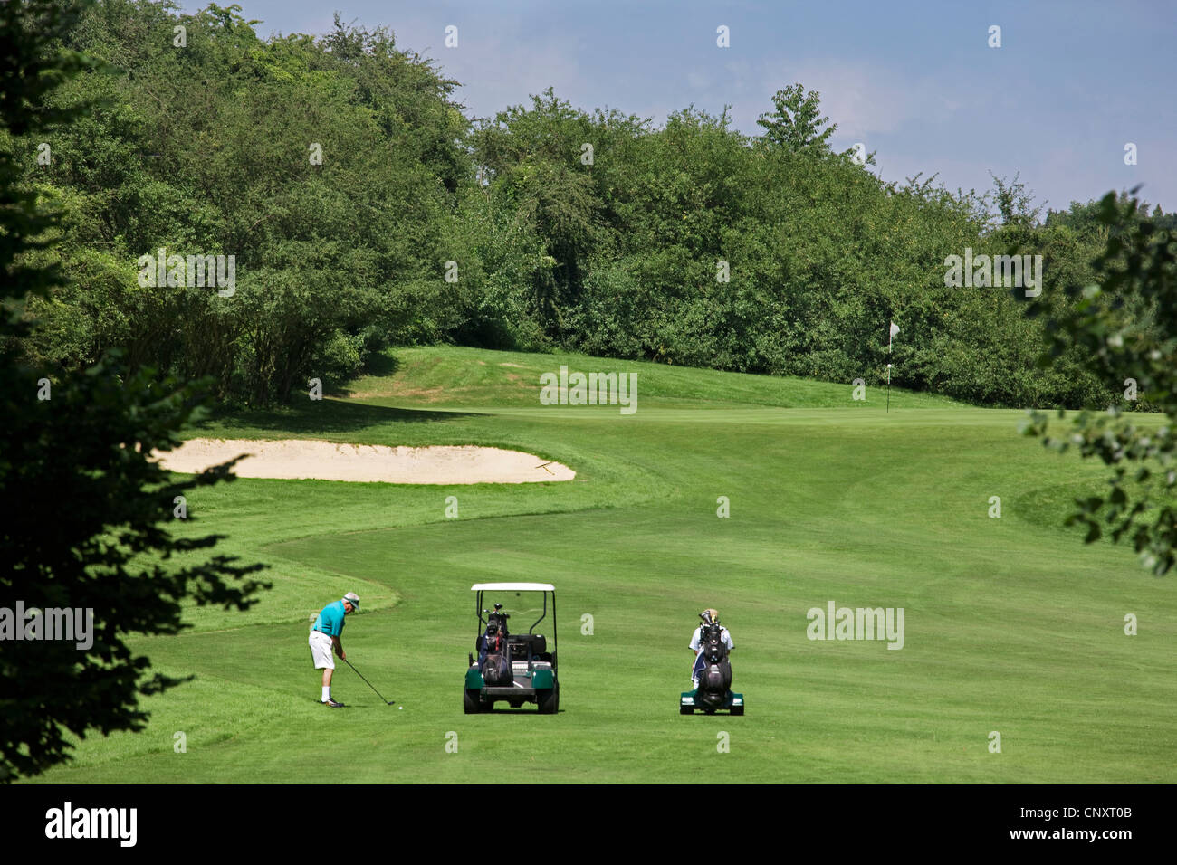 Titolare di pensione o di rendita con golf cart per giocare a golf sul fairway del campo da golf in Europa Foto Stock